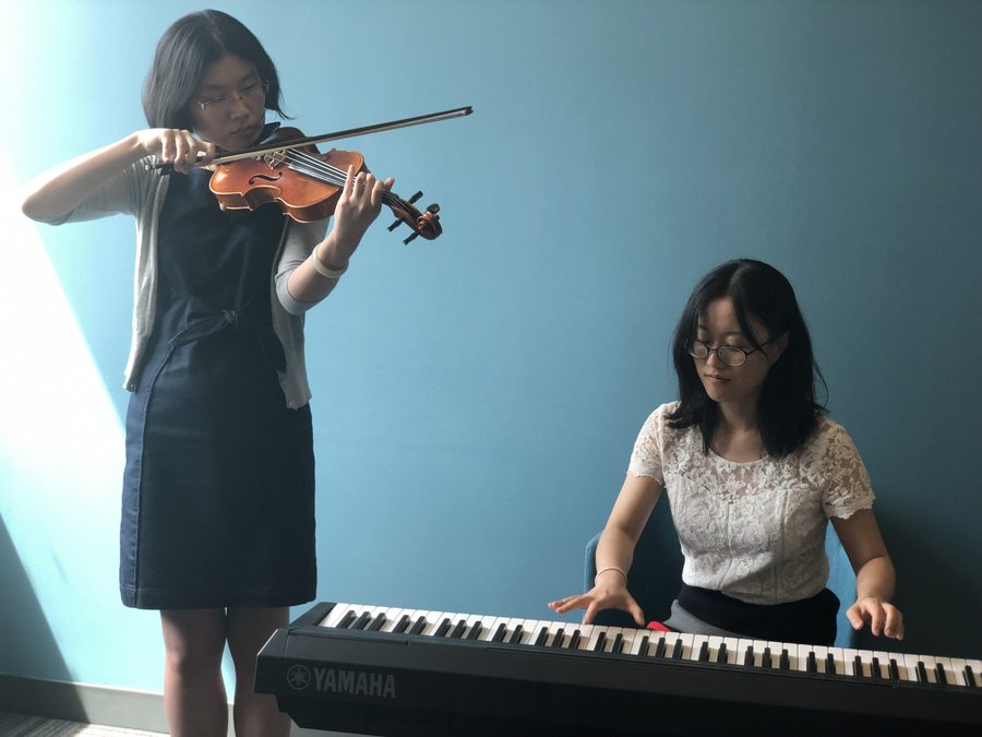Two lab members performing, one on violin and one at a keyboard