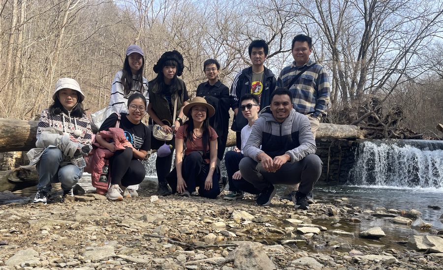 Lab members on a hike beside a creek and waterfall